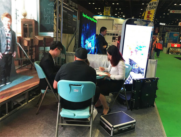 奥兰多橘城会展中心304AM永利展位现场，外贸部经理黄勇强和何巧玲与意向客户在交谈中